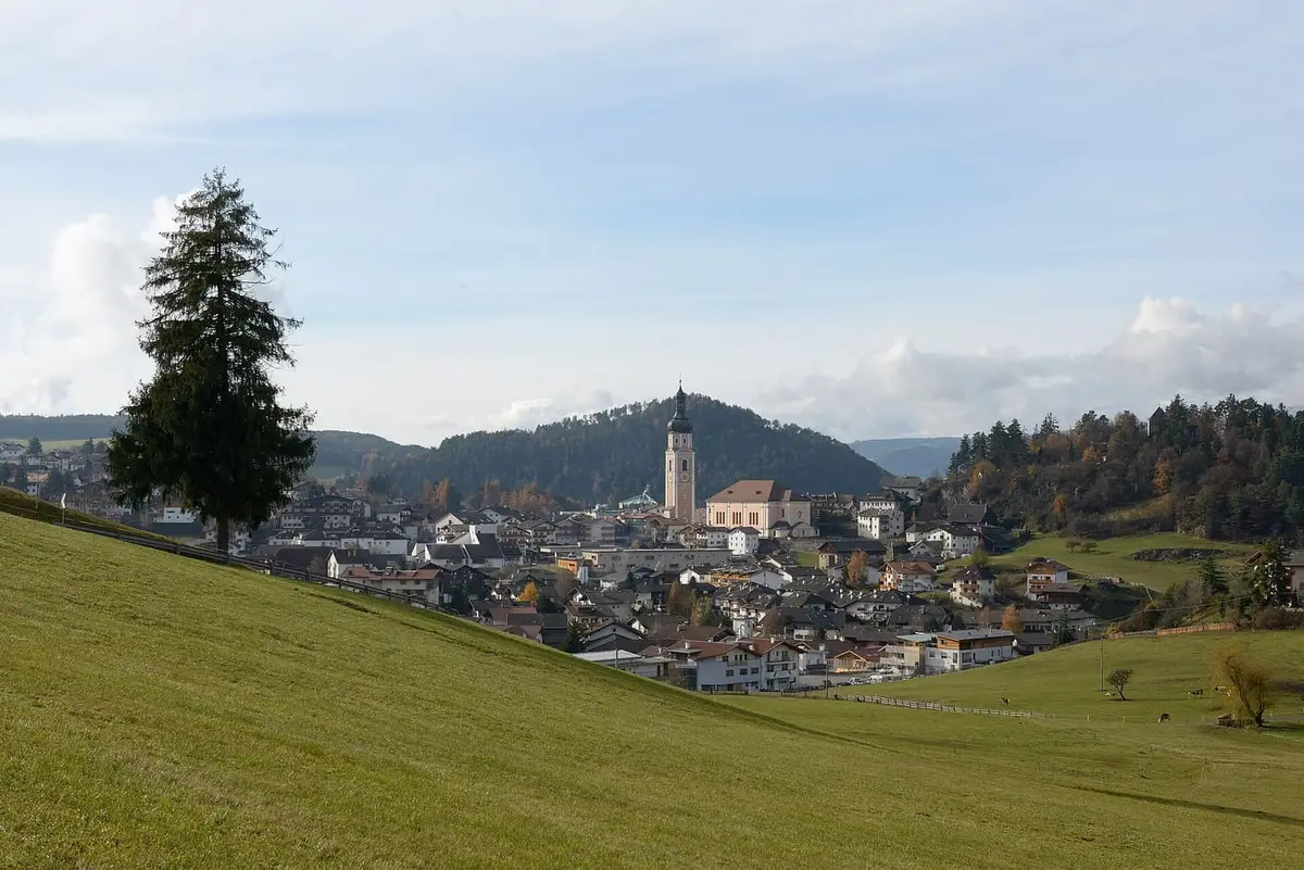 Castelrotto con il campanile, ai piedi dello Sciliar e dell'Alpe di Siusi