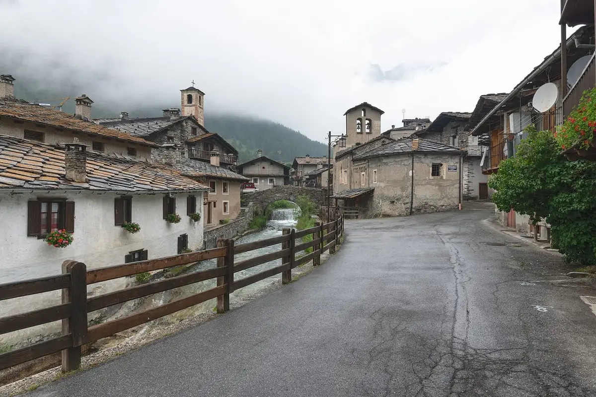 Il borgo alpino di Chianale, in Val Varaita, con le case in pietra sul torrente